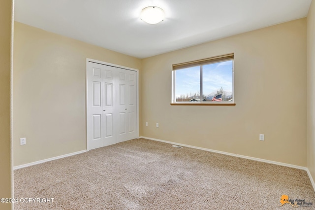 unfurnished bedroom with carpet flooring and a closet