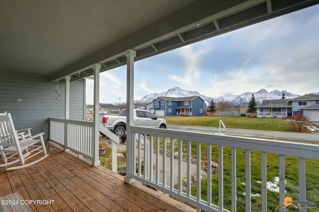 wooden deck with a lawn and a mountain view