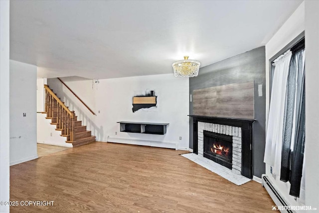 unfurnished living room featuring a fireplace, a baseboard radiator, and hardwood / wood-style floors