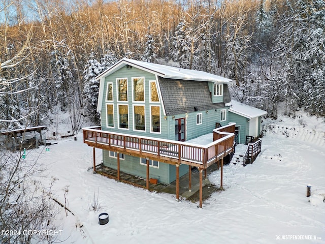 snow covered rear of property featuring a deck