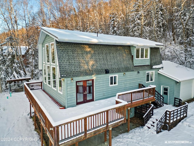 snow covered back of property featuring a wooden deck