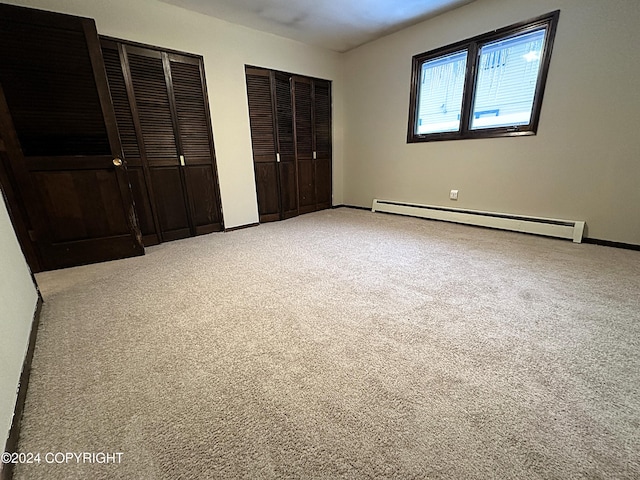 8111 Northview Dr, Anchorage, AK 99504 - unfurnished bedroom featuring a baseboard heating unit, carpet flooring, multiple closets, and baseboards