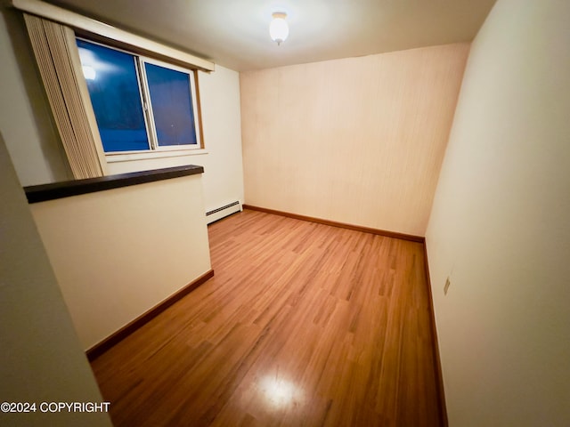 spare room featuring light hardwood / wood-style floors and a baseboard heating unit