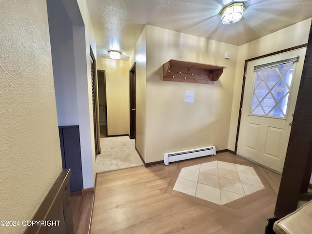 8111 Northview Dr, Anchorage, AK 99504 - entryway featuring baseboard heating, light wood finished floors, baseboards, and a textured ceiling