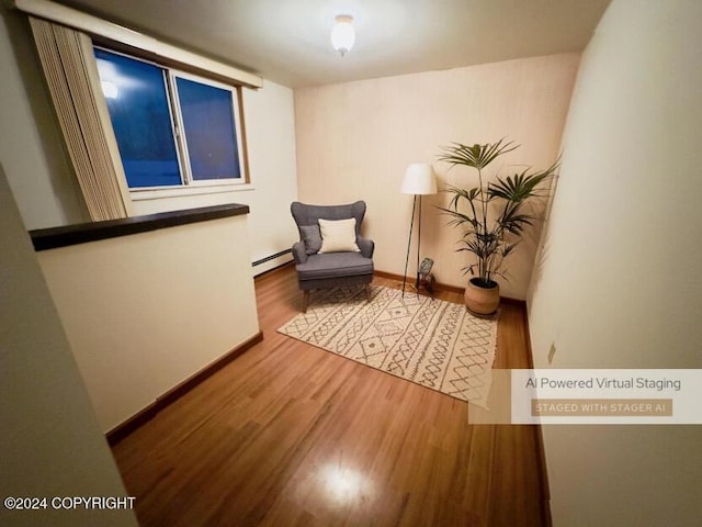 sitting room featuring wood-type flooring and a baseboard radiator