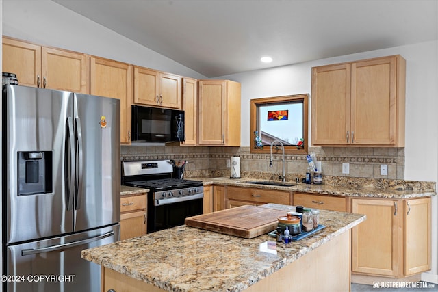 kitchen featuring sink, backsplash, appliances with stainless steel finishes, light brown cabinetry, and vaulted ceiling