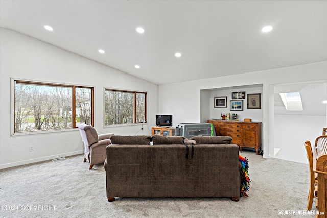 living room featuring lofted ceiling with skylight and light colored carpet