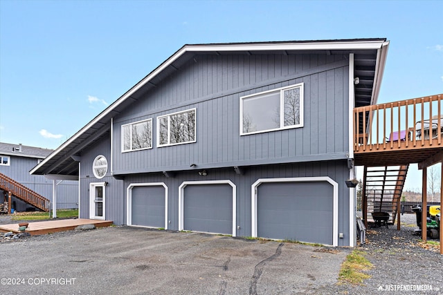 view of front facade featuring a wooden deck and a garage