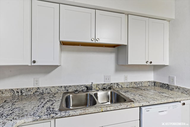 kitchen with dishwasher, white cabinets, and sink