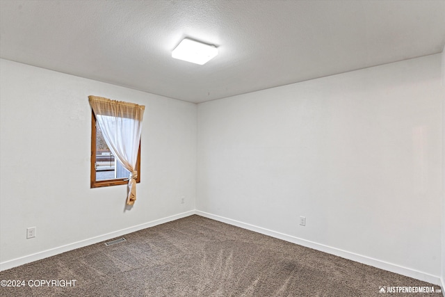 carpeted empty room with a textured ceiling