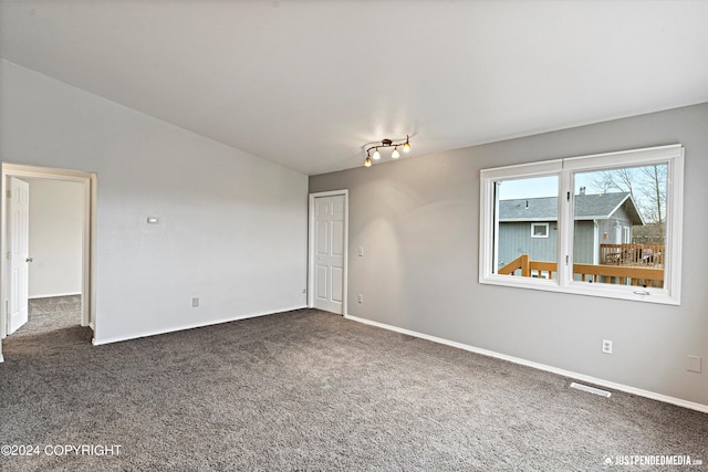 carpeted spare room with lofted ceiling