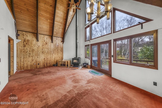 4480 E 138th Ave, Anchorage, AK 99516 - unfurnished living room with high vaulted ceiling, a wood stove, carpet flooring, healthy amount of natural light, and a chandelier