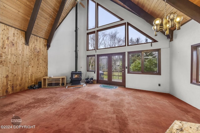 4480 E 138th Ave, Anchorage, AK 99516 - unfurnished living room with a wood stove, high vaulted ceiling, wooden ceiling with exposed beams, carpet, and a chandelier