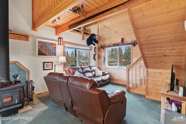 carpeted living room with wood ceiling, a wood stove, track lighting, beam ceiling, and wood walls