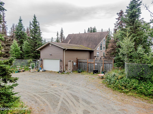 view of home's exterior featuring driveway and fence