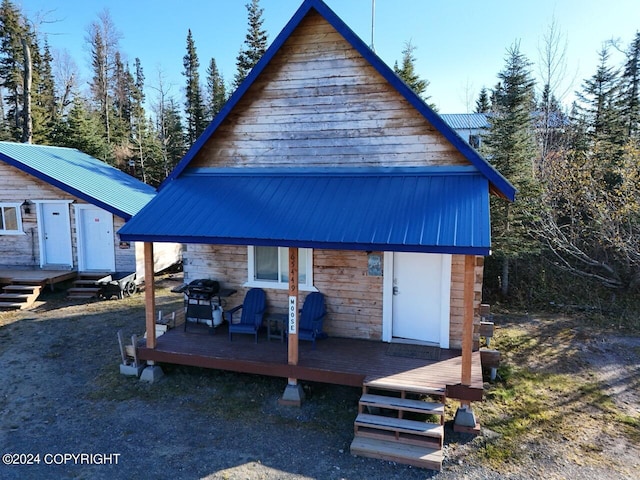 rear view of house featuring a wooden deck