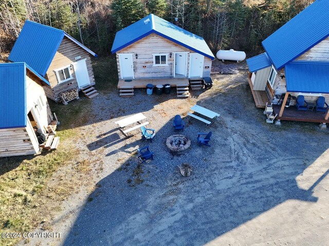 65449 Lingonberry Rd, Ninilchik, AK 99639 - exterior space featuring entry steps, a wooden deck, an outbuilding, an outdoor fire pit, and a forest view