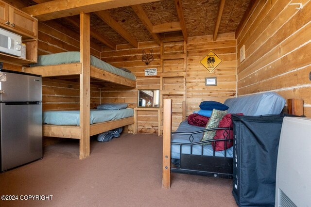 65449 Lingonberry Rd, Ninilchik, AK 99639 - bedroom featuring carpet, wooden walls, and freestanding refrigerator