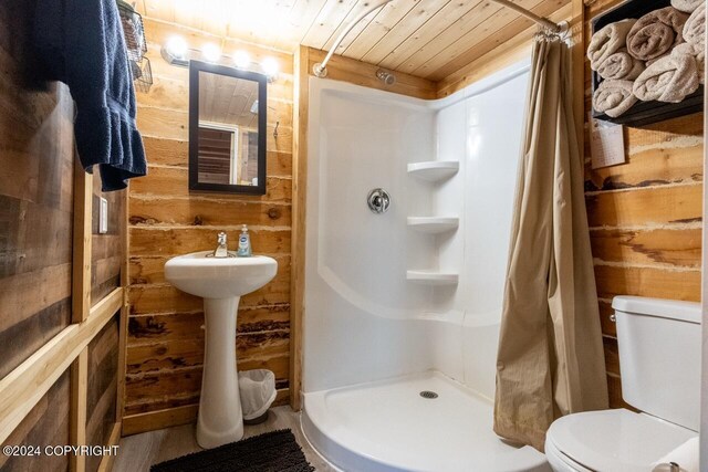 65449 Lingonberry Rd, Ninilchik, AK 99639 - bathroom featuring a shower stall, wood walls, wooden ceiling, and toilet