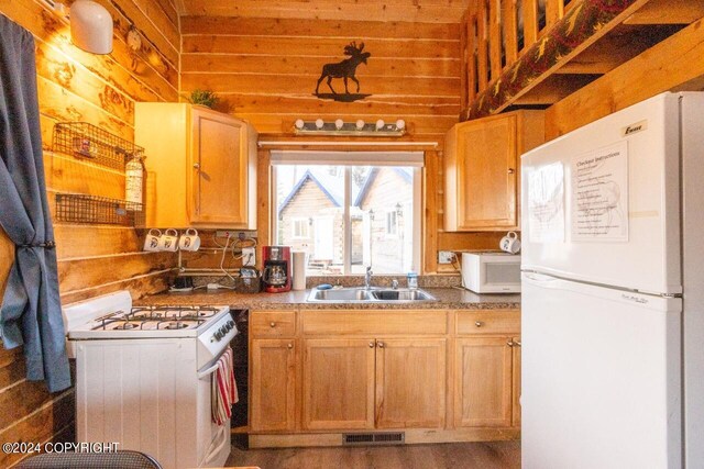 65449 Lingonberry Rd, Ninilchik, AK 99639 - kitchen featuring wood walls, wood finished floors, visible vents, a sink, and white appliances