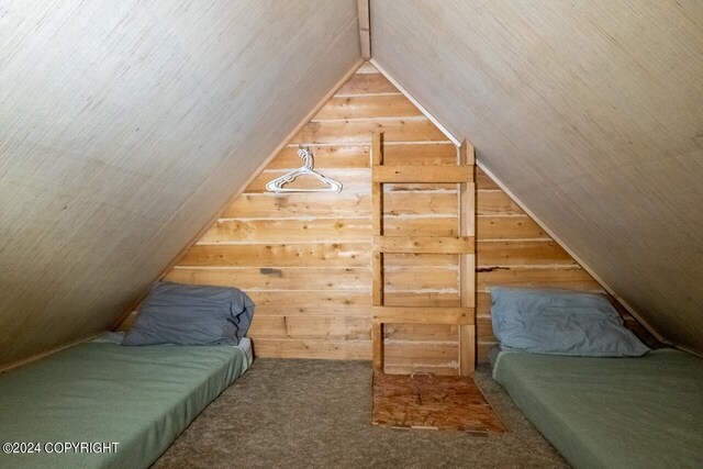 65449 Lingonberry Rd, Ninilchik, AK 99639 - bedroom featuring wooden walls, vaulted ceiling, and carpet flooring