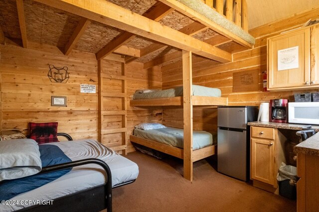 65449 Lingonberry Rd, Ninilchik, AK 99639 - carpeted bedroom featuring freestanding refrigerator and wood walls