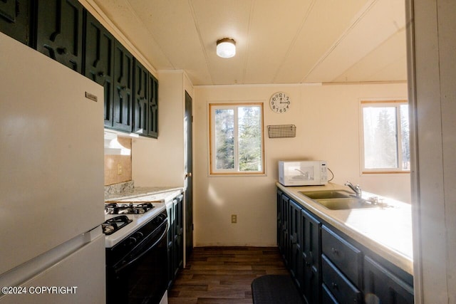 kitchen featuring white appliances, green cabinets, sink, and dark hardwood / wood-style floors