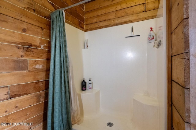 bathroom featuring a shower with curtain and wood walls