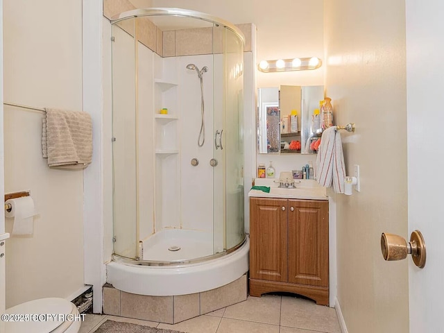 full bath with a shower stall, vanity, tile patterned flooring, and toilet