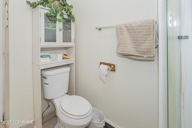 bathroom featuring baseboards and toilet
