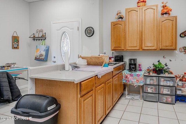 kitchen with a sink, light tile patterned flooring, and light countertops