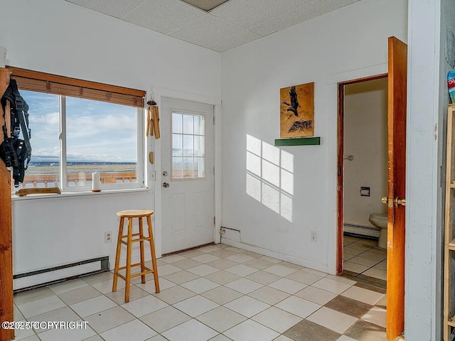 foyer entrance featuring baseboard heating, a baseboard radiator, and a drop ceiling
