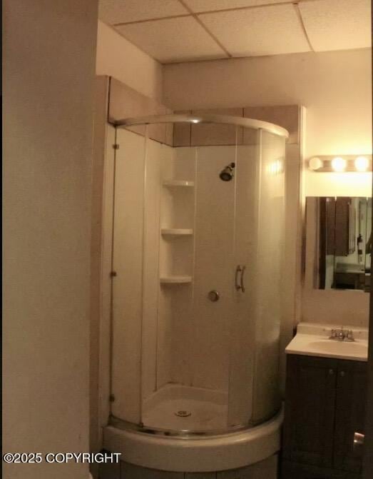 full bathroom featuring a stall shower, a paneled ceiling, and vanity