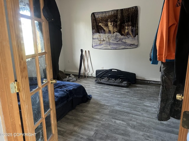 bedroom with wood finished floors and a baseboard heating unit