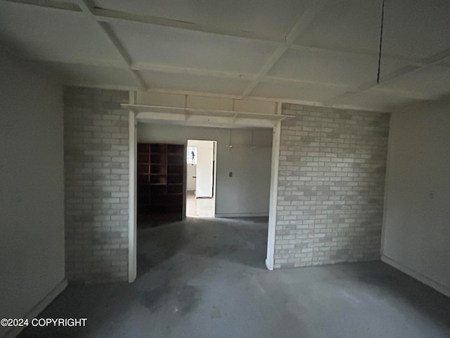 empty room featuring concrete flooring and brick wall