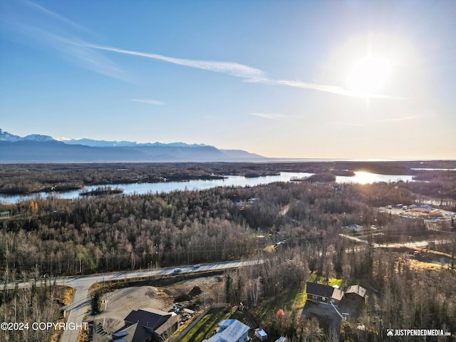 aerial view at dusk featuring a water and mountain view