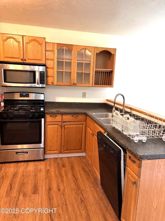 7025 S Gilleys Cir, Wasilla, AK 99654 - kitchen featuring appliances with stainless steel finishes, dark wood-style floors, dark countertops, and glass insert cabinets