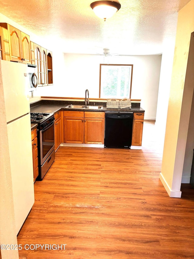 7025 S Gilleys Cir, Wasilla, AK 99654 - kitchen featuring dishwasher, freestanding refrigerator, stainless steel gas stove, dark countertops, and light wood-style flooring