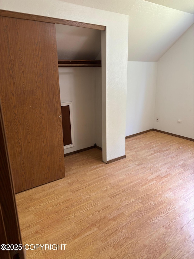 7025 S Gilleys Cir, Wasilla, AK 99654 - unfurnished bedroom featuring light wood-style flooring, a closet, and vaulted ceiling