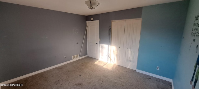 unfurnished bedroom with a closet and carpet floors