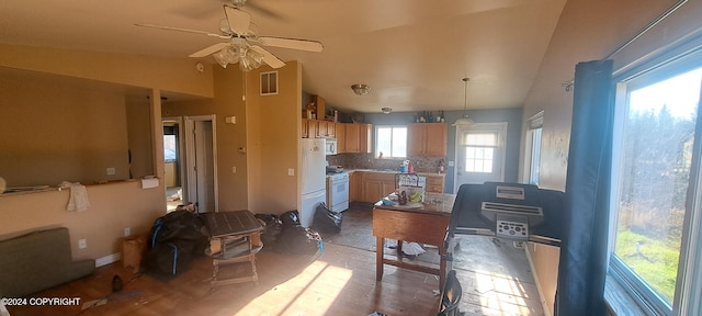 kitchen featuring lofted ceiling, ceiling fan, backsplash, decorative light fixtures, and white appliances