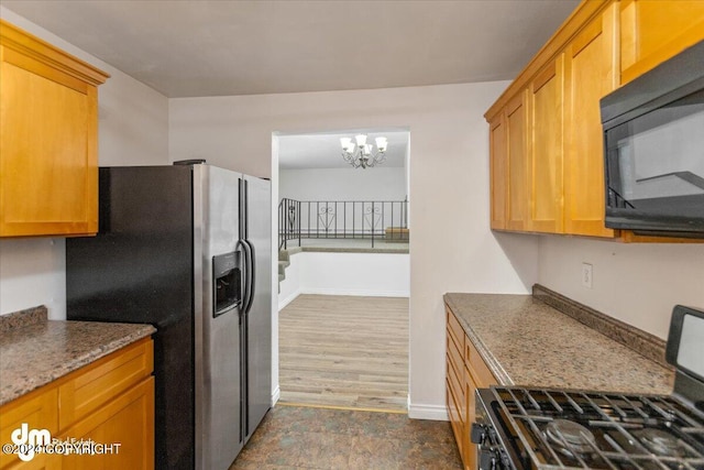 kitchen featuring stone counters, stainless steel fridge with ice dispenser, an inviting chandelier, dark hardwood / wood-style floors, and range with gas stovetop