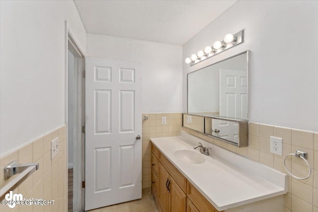 bathroom featuring vanity and tile walls