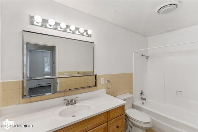 full bathroom with tile walls, vanity, toilet, and shower / bath combination