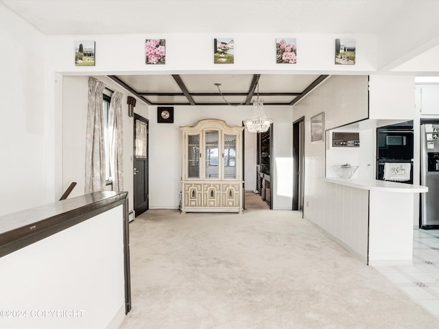 kitchen with stainless steel fridge, light colored carpet, double oven, pendant lighting, and a chandelier