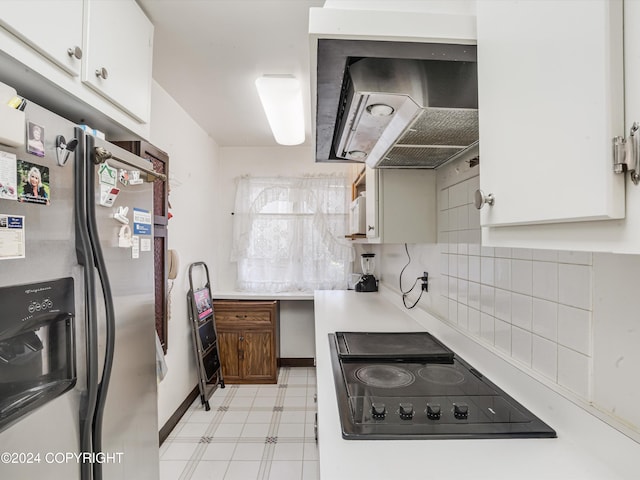 kitchen featuring stainless steel fridge, white cabinetry, black electric stovetop, and range hood