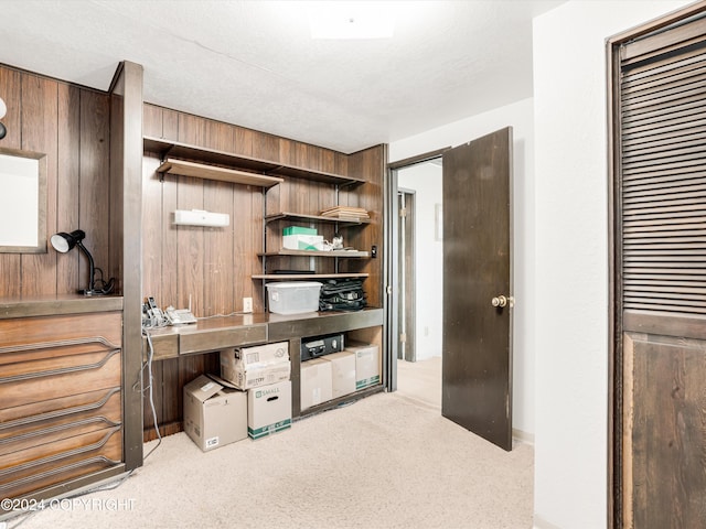 carpeted office space with wood walls and a textured ceiling