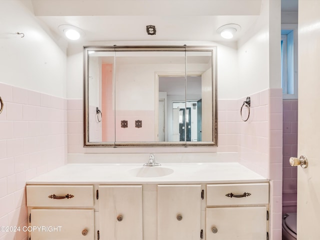 bathroom with vanity and tile walls