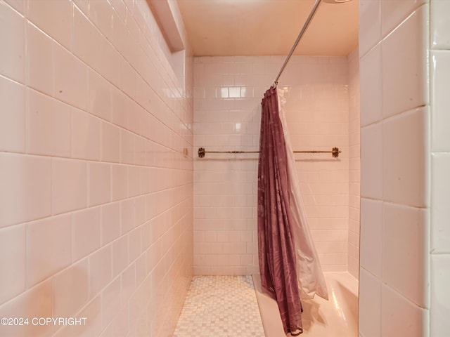 bathroom featuring walk in shower and tile walls