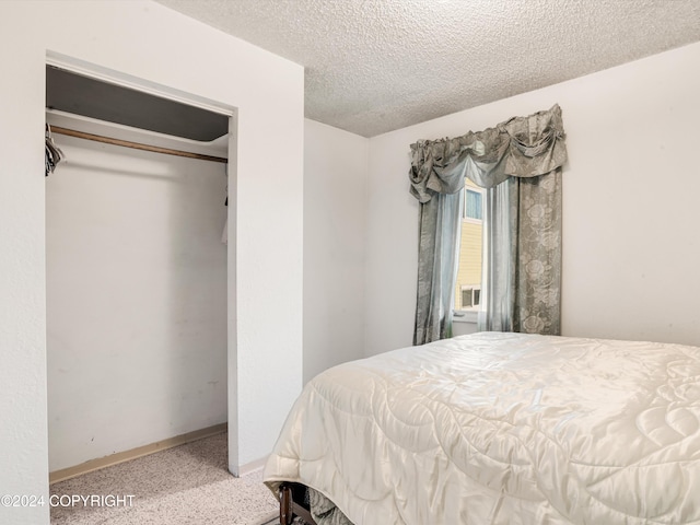 bedroom featuring a textured ceiling, carpet floors, and a closet